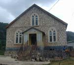 Photo of cut-stone building next to basic school